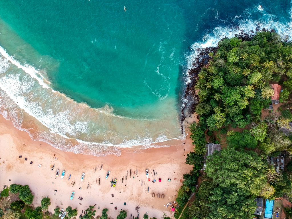 A stunning aerial shot of a vibrant tropical beach in Sri Lanka with lush greenery and turquoise waters.