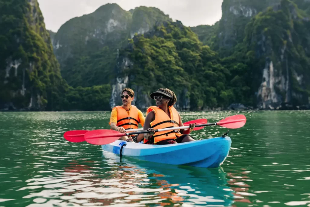 Travellers kayaking among the dramatic limestone islands of Ha Long Bay