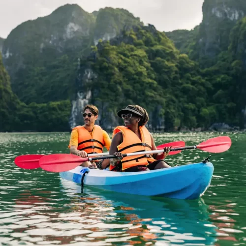 Travellers kayaking among the dramatic limestone islands of Ha Long Bay
